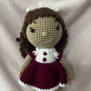Crocheted doll with brown curly hair
